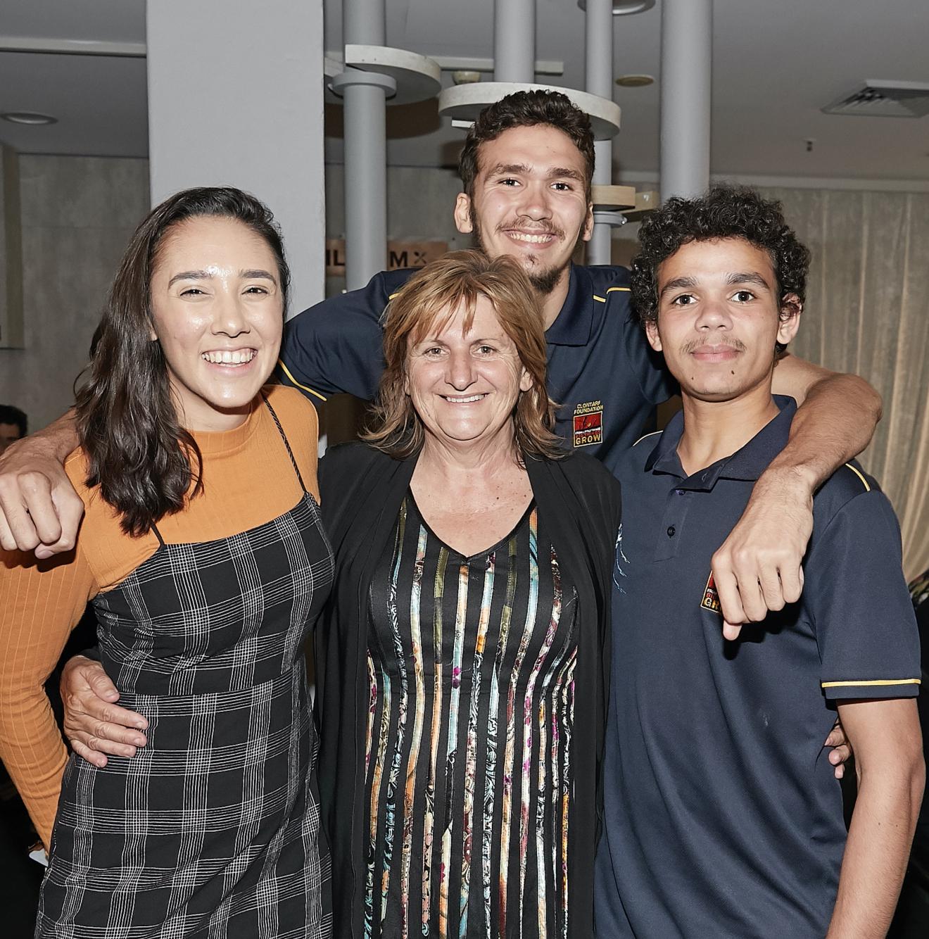Four Indigenous people in a group photo. The central figure is UTS Elder-in-Residence Aunty Glendra Stubbs. To her right is a female Indigenous student, to her left and behind her are two young Indigenous high school students.