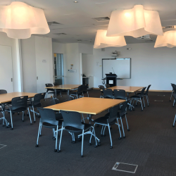The seminar room in building 8: groups of desks with four chairs each