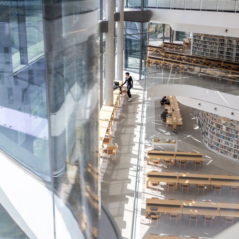 The University of Technology Sydney Library reading room taken from above, looking into the space with students at desks and bookshelves in the background