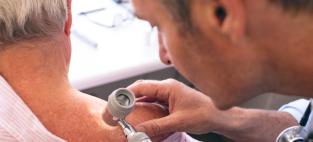 Dermatologist examining patient. Adobe Stock