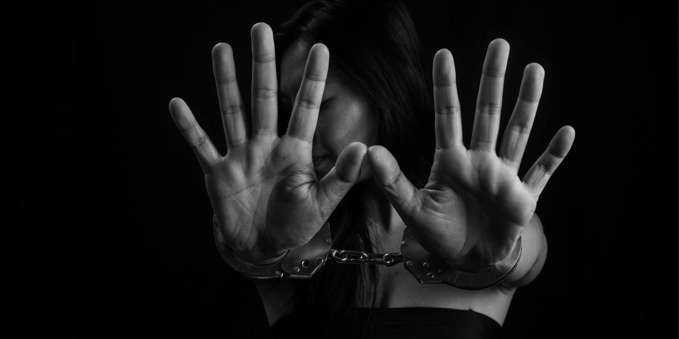 Persona handcuffed showing both hands in black and white portrait