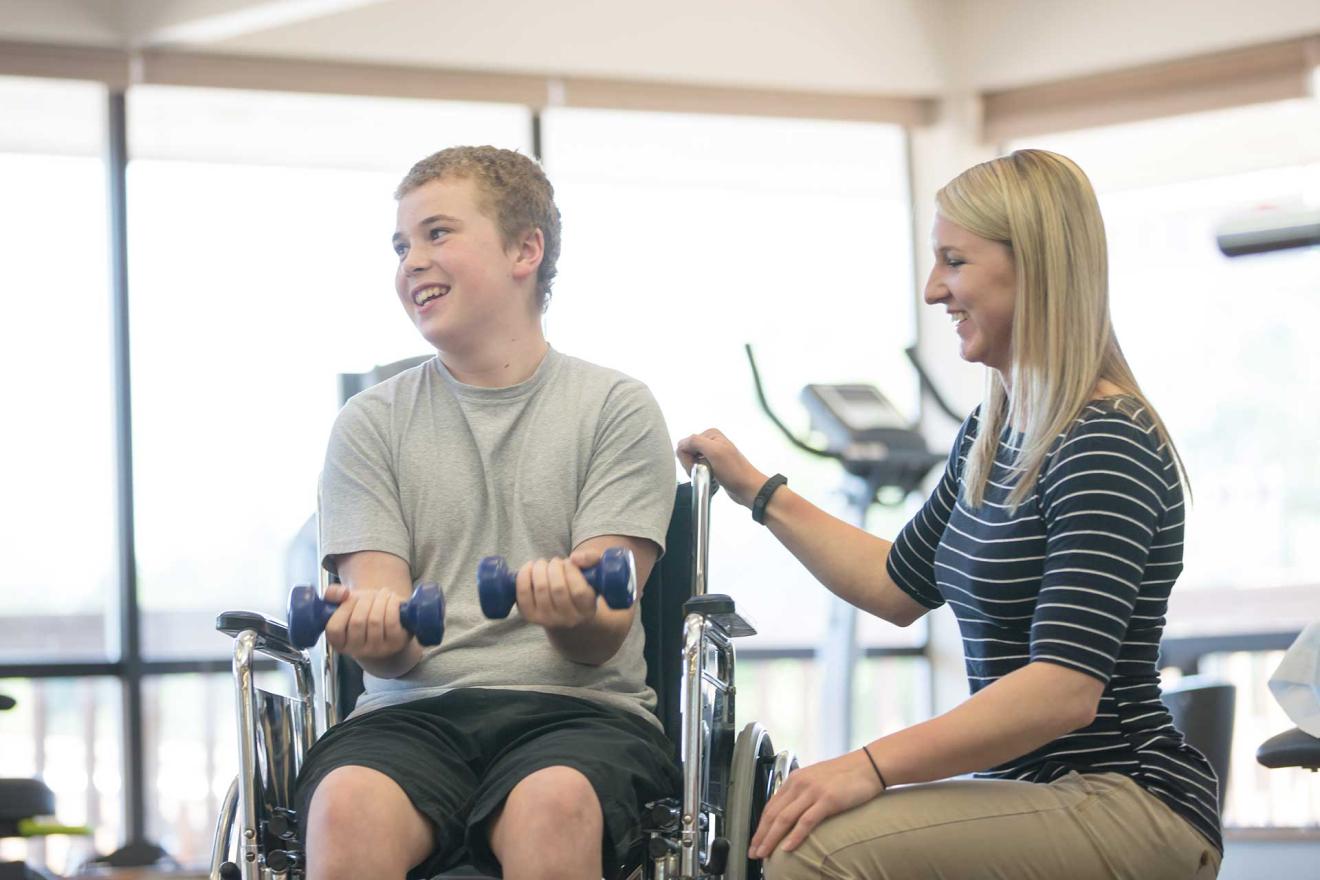 Boy in wheelchair lifts weights