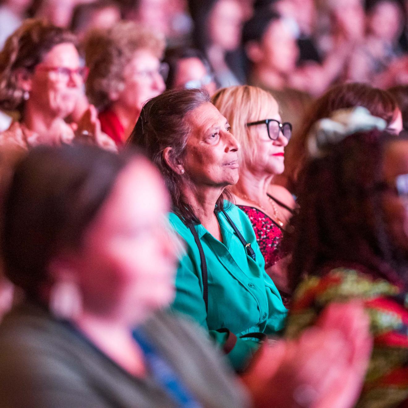 Crowd watching a panel talk.