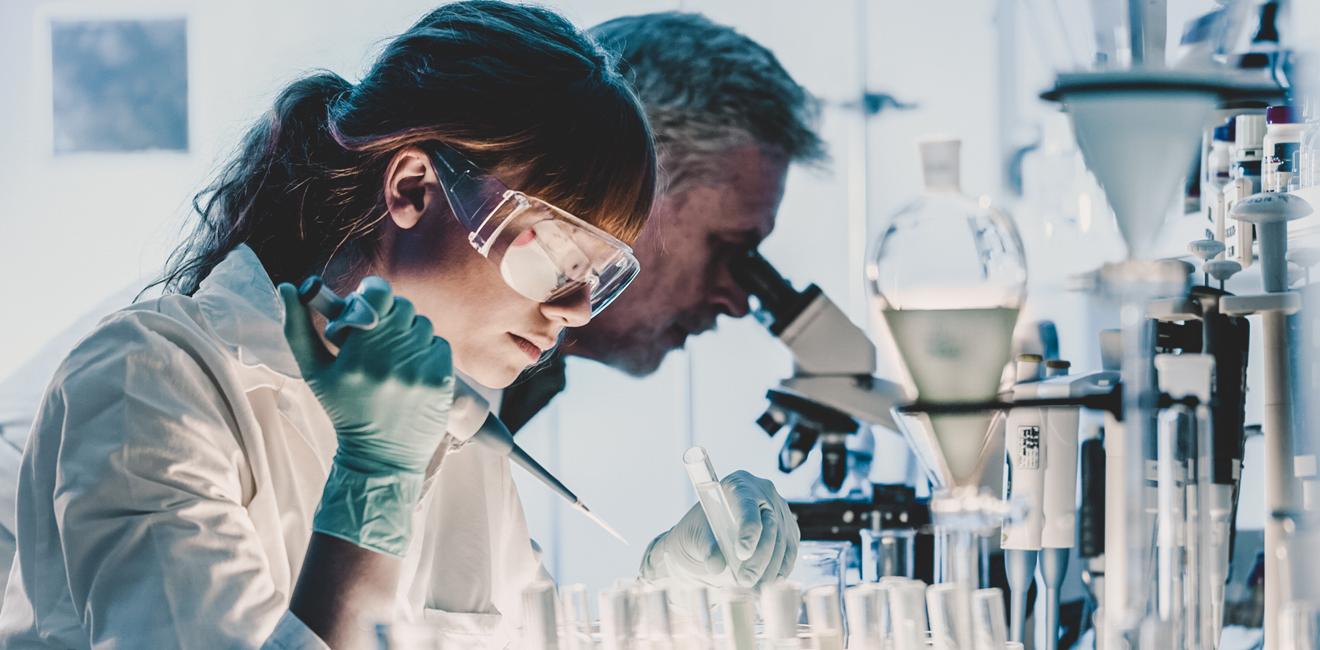 A scientist in a lab doing an experiment with test tubes