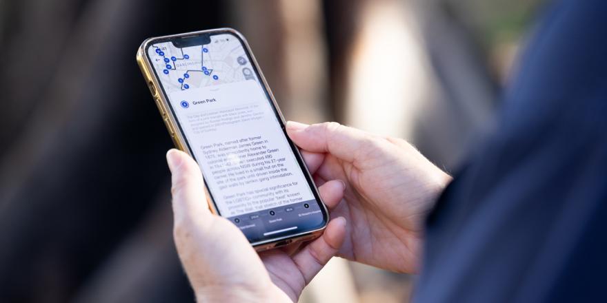 Person holding a mobile phone and looking at walking app