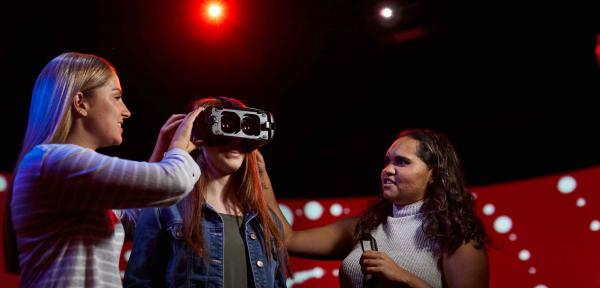 Three female students using a VR set