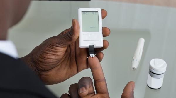Man doing a blood sugar test on his finger