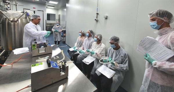 Teacher in lab coat instructing students