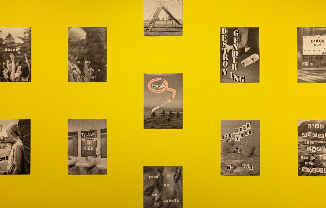 A close up of  black and white collages displayed on a yellow wall 