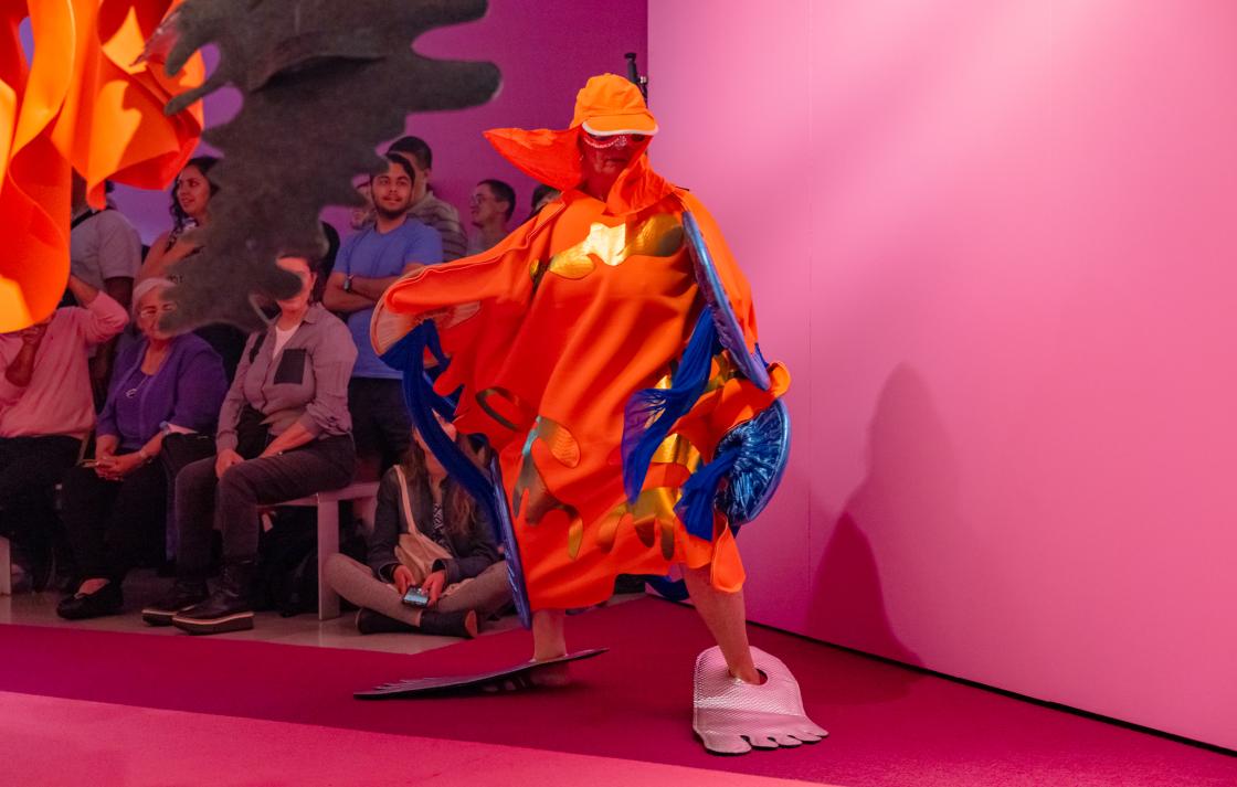 A person in an orange costume poses