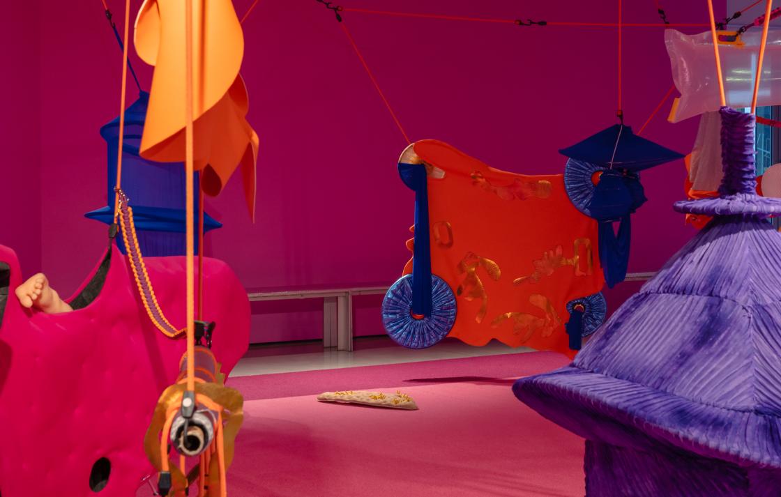 A colourful art installation in a room painted pink