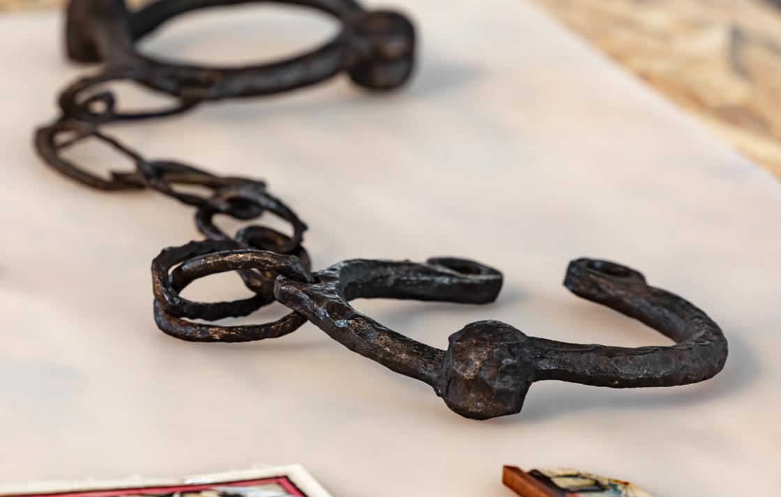 A view of leg manacles and a children's game in an acrylic box