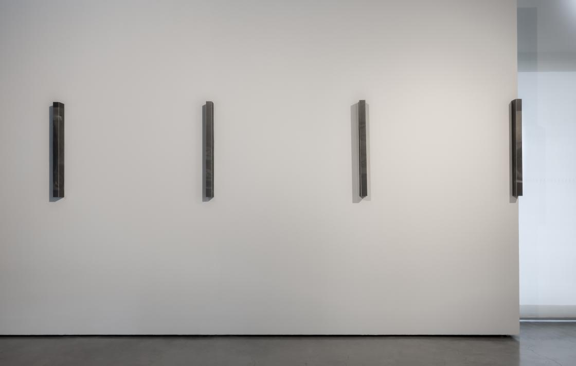 Four delicate graphite on paper artworks on a white wall