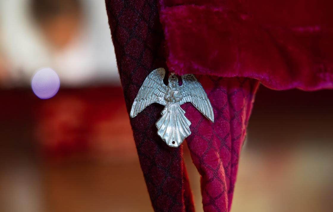 A close up photo of a silver angel charm