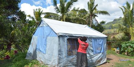 A woman fixes an emergency tent in the Pacific Islands