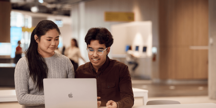 Two students sharing a laptop and collaborating inside UTS modernised campus