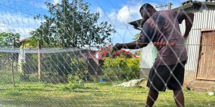 A Fijian man is fixing a fishing net