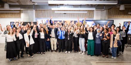 Teams and supporters of the 2024 Allens Neota Law Tech Challenge with hands in the air