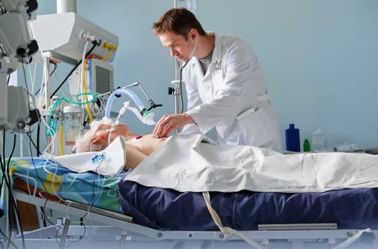 Doctor checking a patient who is using a ventilator