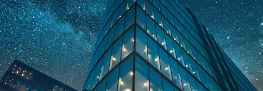 Vivid image of glass building against a starry night sky