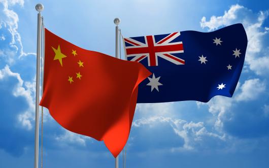 Australia and China flags against blue sky
