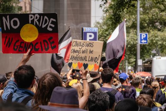 Protest with signs that say: No Pride in Genocide and Always was, always will be, Aboriginal land.