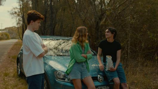 Image from short film The Trip which sees three characters talking around a car