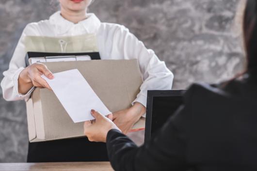 woman hands in resignation letter