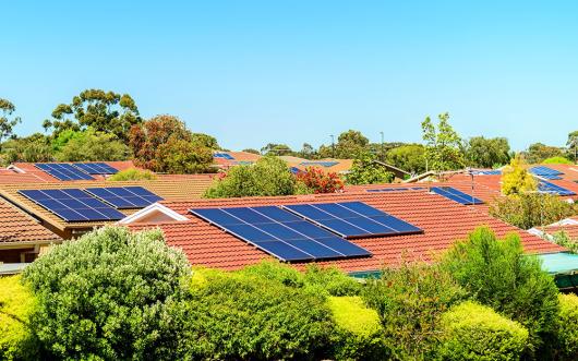 Stock picture of solar panels on the tiled rooves of a suburban neighbourhood