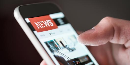 Man reading online news on website with mobile