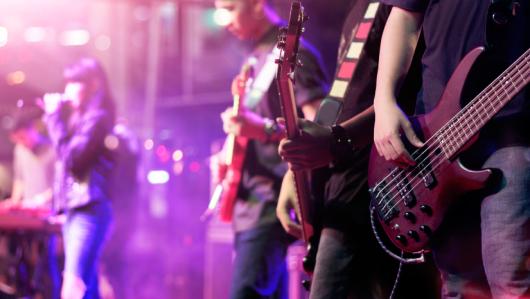 Guitarists and singer on stage. Adobe Stock