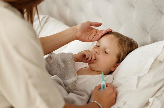 Stock picture of a mother tending a sick child who is coughing