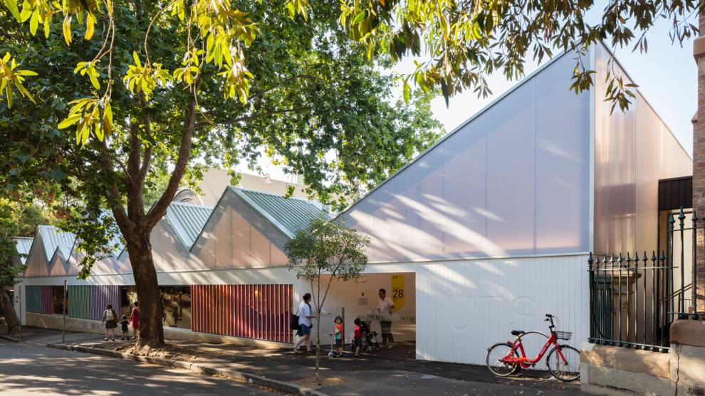 The front entrance to Blackfriars Child Care centre. Parents and children are entering and there is a bicycle locked up to the right.