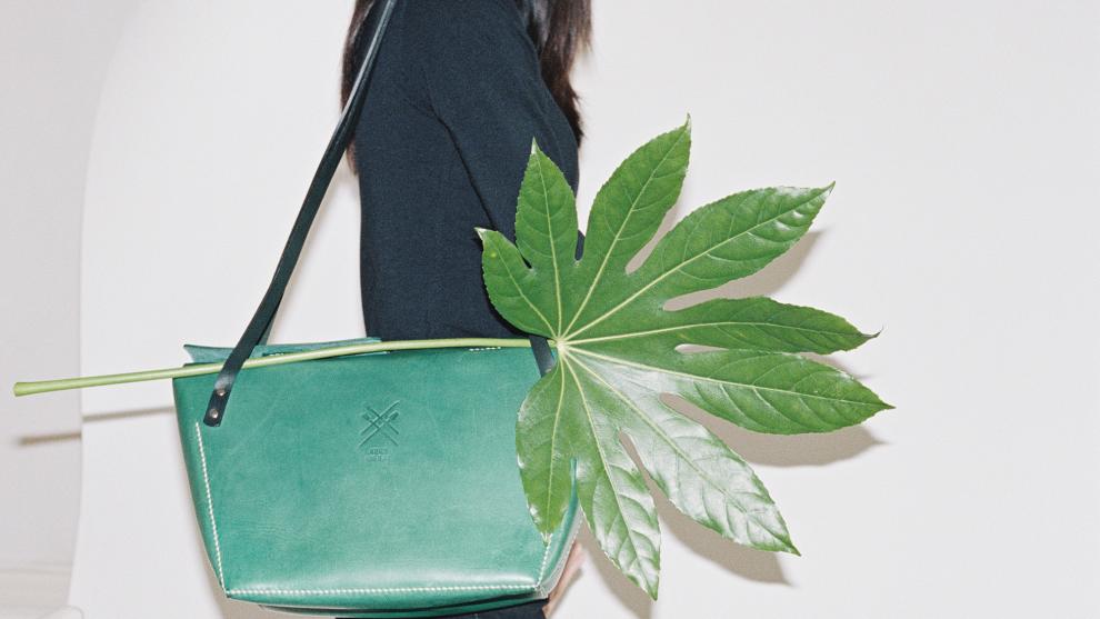 Green shoulder bag and a palm frond.