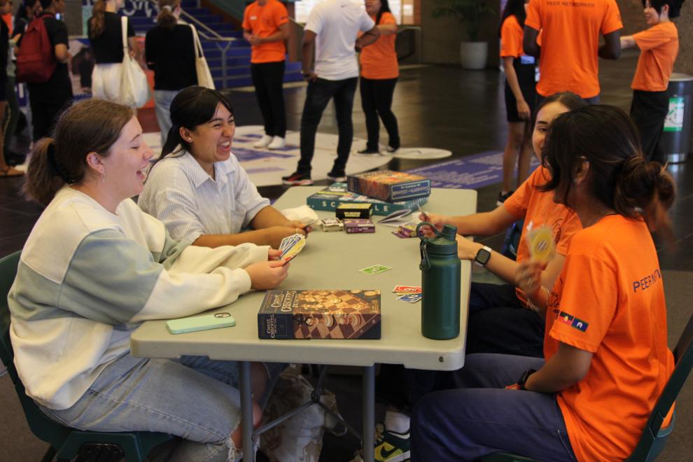 Peer Networkers playing a board game with students