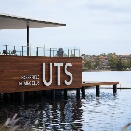 UTS Rowing Club with grass in the foreground and water around it