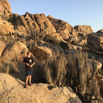 boy standing among rocks