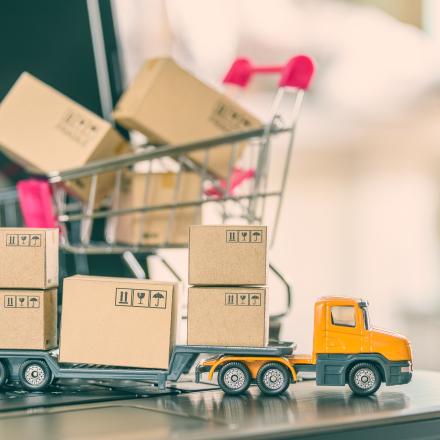 A photo of a toy truck and a toy shopping trolley full of tiny packages