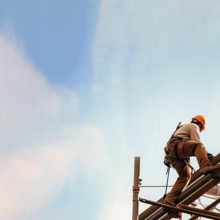 Construction worker on a site wearing construction safety equipment working at height