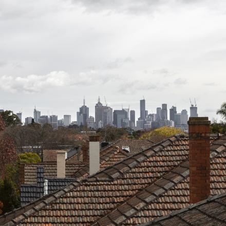 Skyline of Melbourne above some residential buildings.