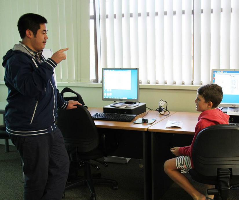 Chau Au talking to a student at Code Club