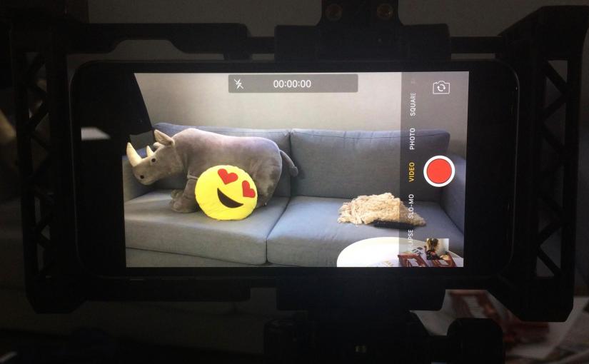 An iPhone filming a couch with cushions on it