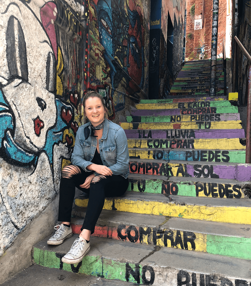 FASS Argentina ICS study tour Alana sitting on colorful steps with graffiti on walls