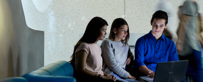 3 Students looking at the same laptop