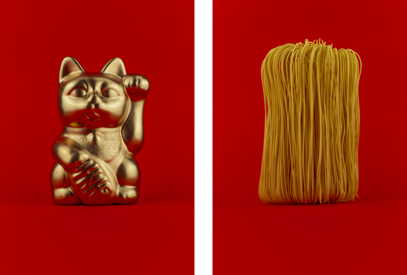Left: gold waving cat figurine, Right: Dried noodles, both on red background