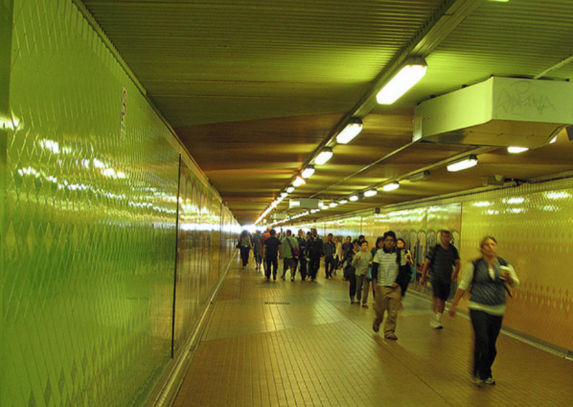 Green and yellow tunnel with people walking
