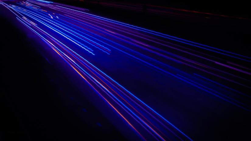 Red and blue bright lights in straight and wavy lines to represent photons