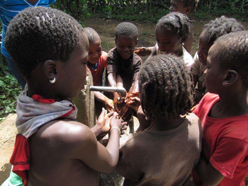 Haitian children wash their hands during a cholera vaccination campaign.