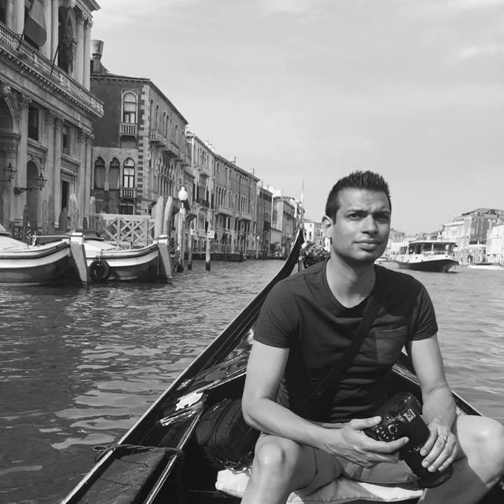 Akash Arora sitting in a canal boat in Venice - black and white