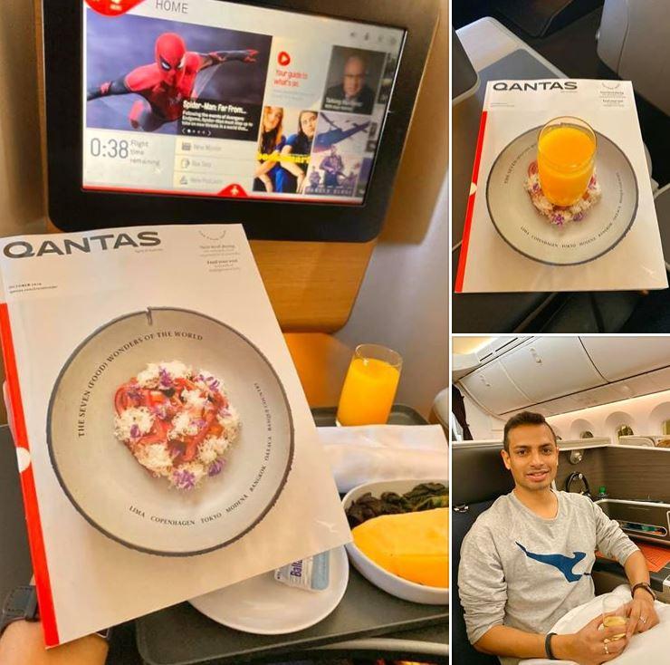 Image of Akash on board Qantas flight looking at Qantas magazine